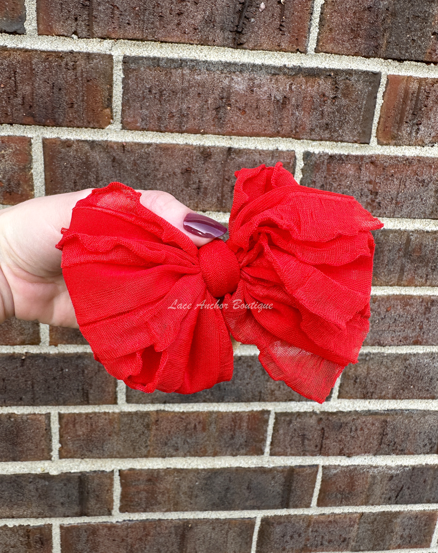 baby headband wrap on nylon band. Red bow with ruffled texture.