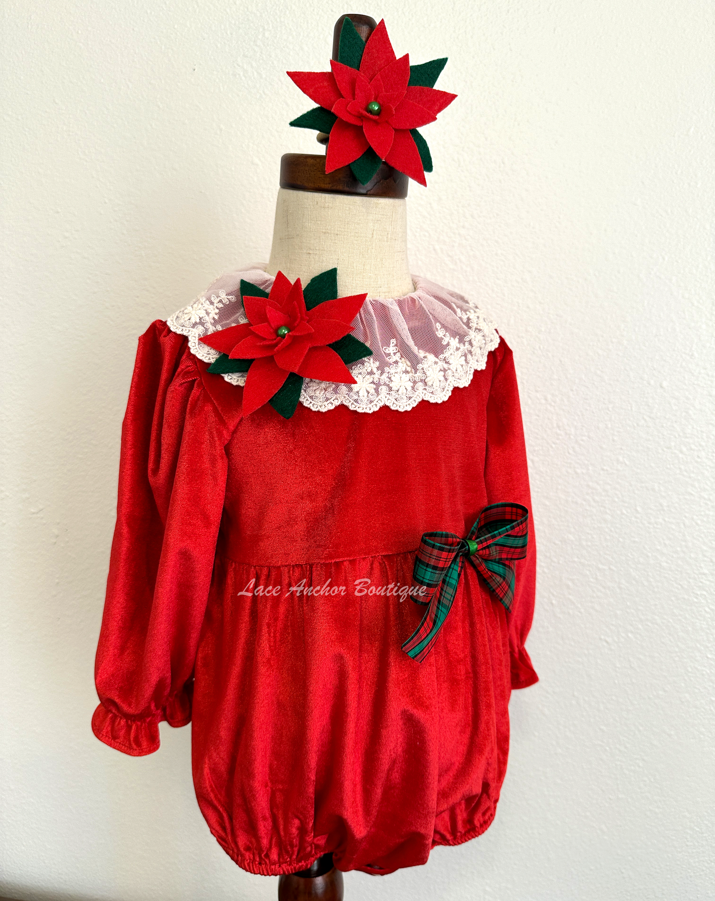 Christmas themed baby girls romper with red velvet, lace collar, 3D felt poinsettia flowers, and a vintage green and red bow.