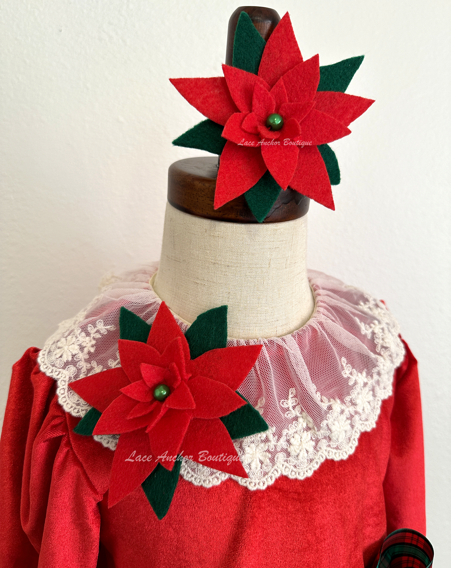 Christmas themed baby girls romper with red velvet, lace collar, 3D felt poinsettia flowers, and a vintage green and red bow.