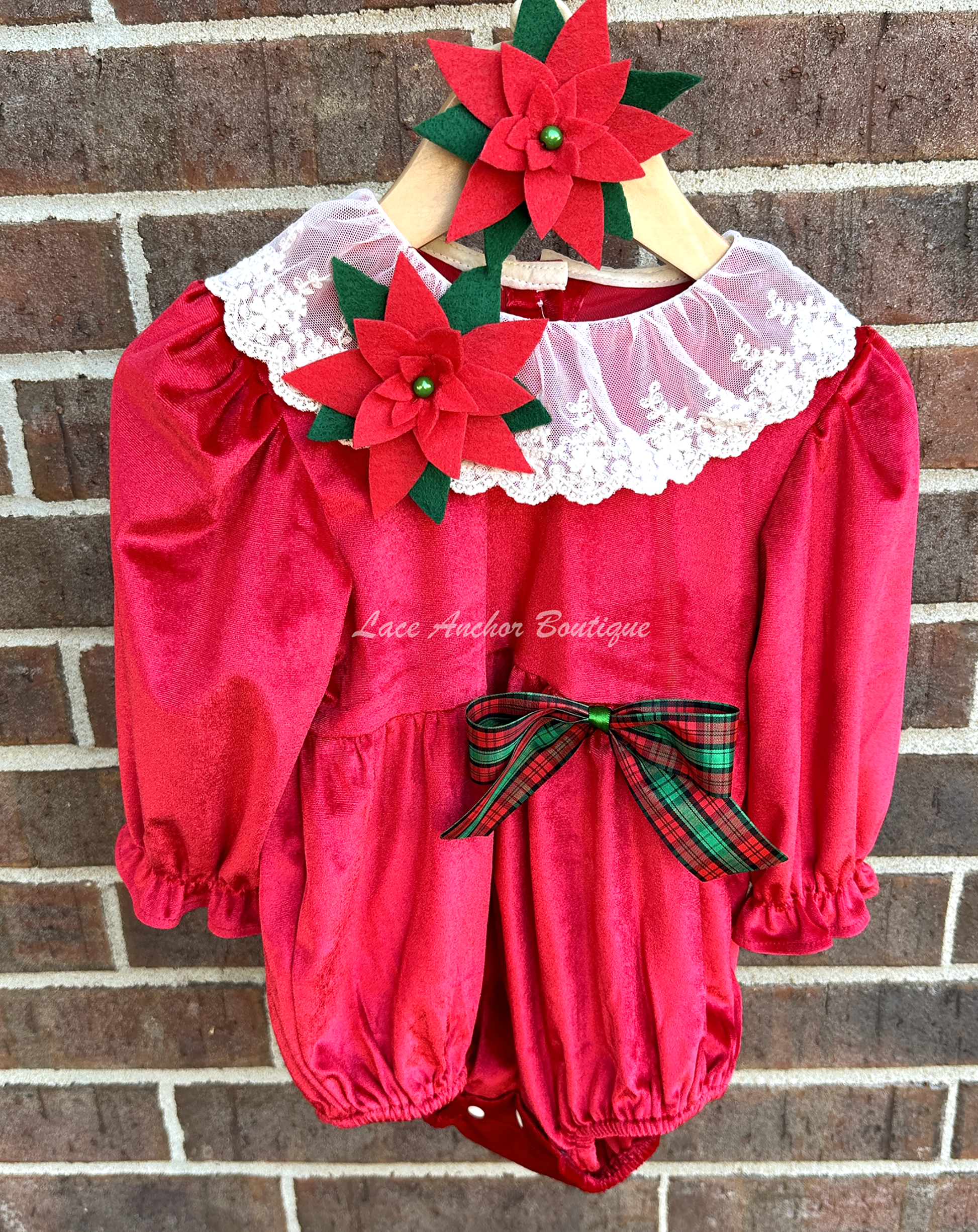 Christmas themed baby girls romper with red velvet, lace collar, 3D felt poinsettia flowers, and a vintage green and red bow.