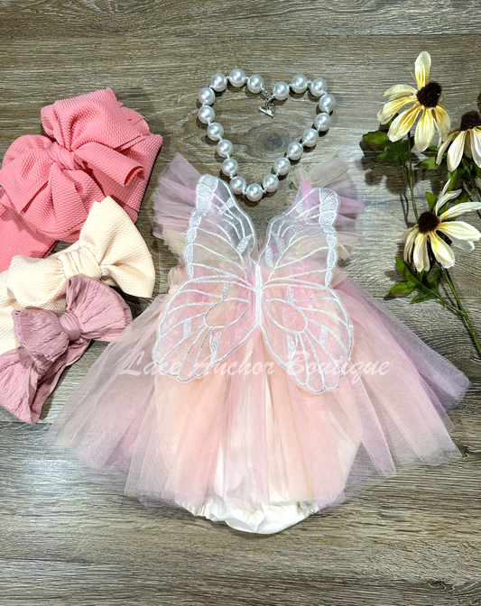 baby girls pastel peach, coral skirted romper with fairy wings. Girls dress with embroidered butterfly wings.