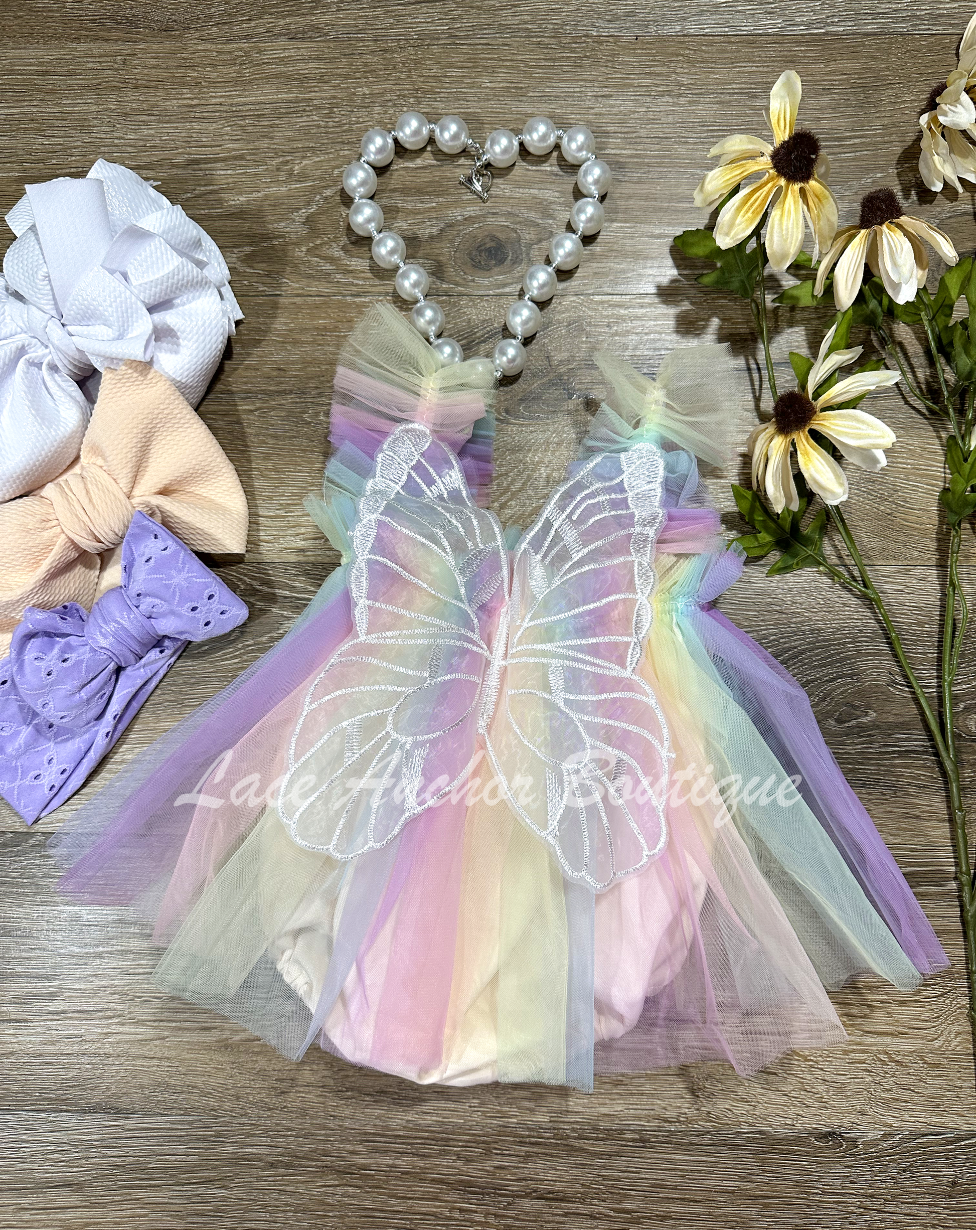 baby girls pastel lilac purple, yelow, blue, peach skirted romper with fairy wings. Girls dress with embroidered butterfly wings.