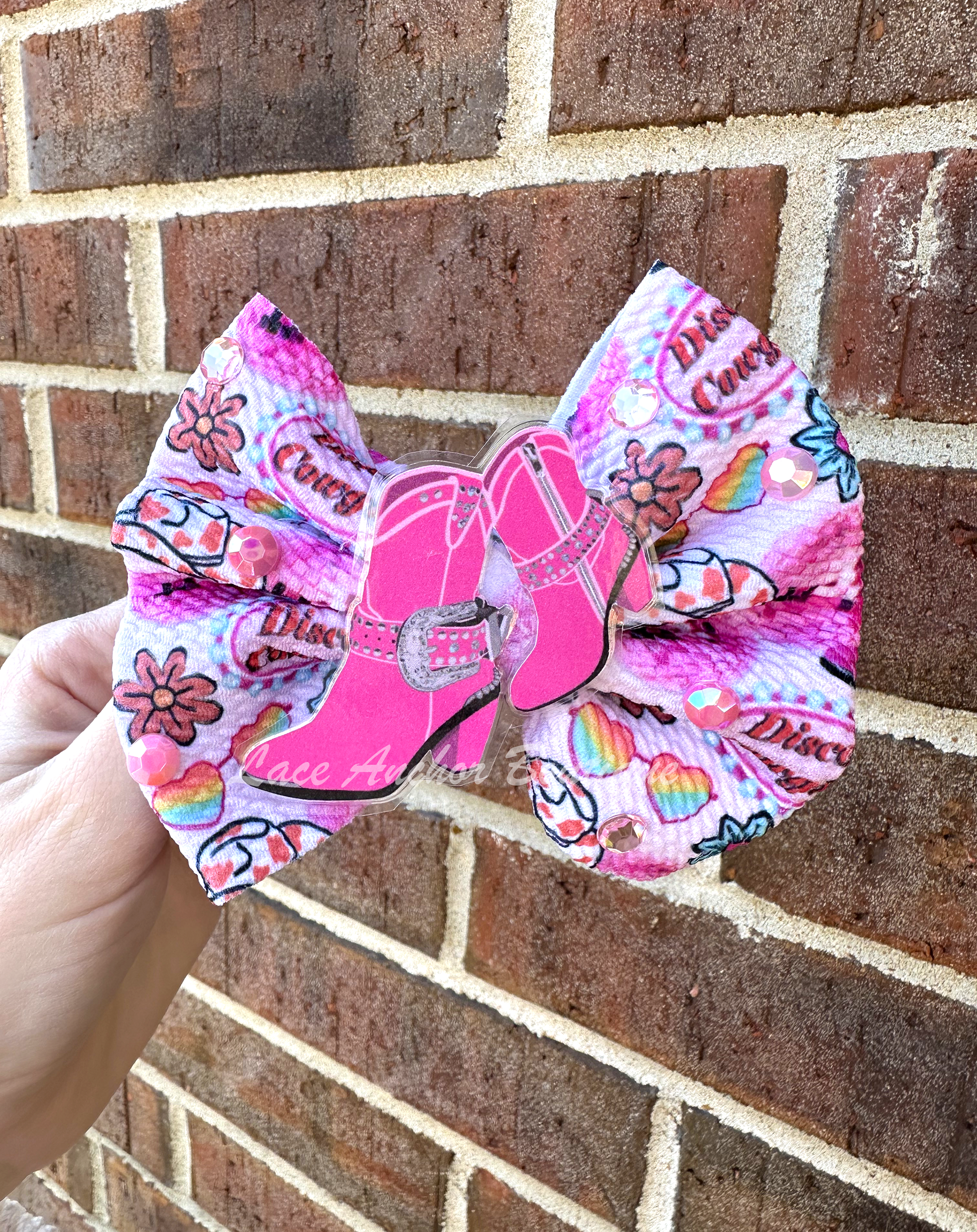 disco cowgirl custom handmade girls hair bow in pink with cowgirl glam boots center and rhinestones to match.