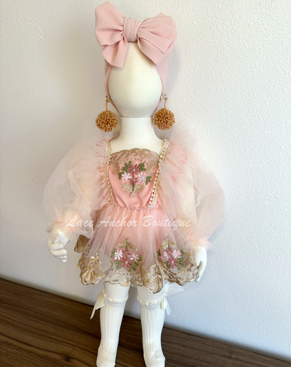 baby toddler girls flower girl romper with long puff sleeves, embroidered gold floral trim, skirt, and tied back. In blush light pink.