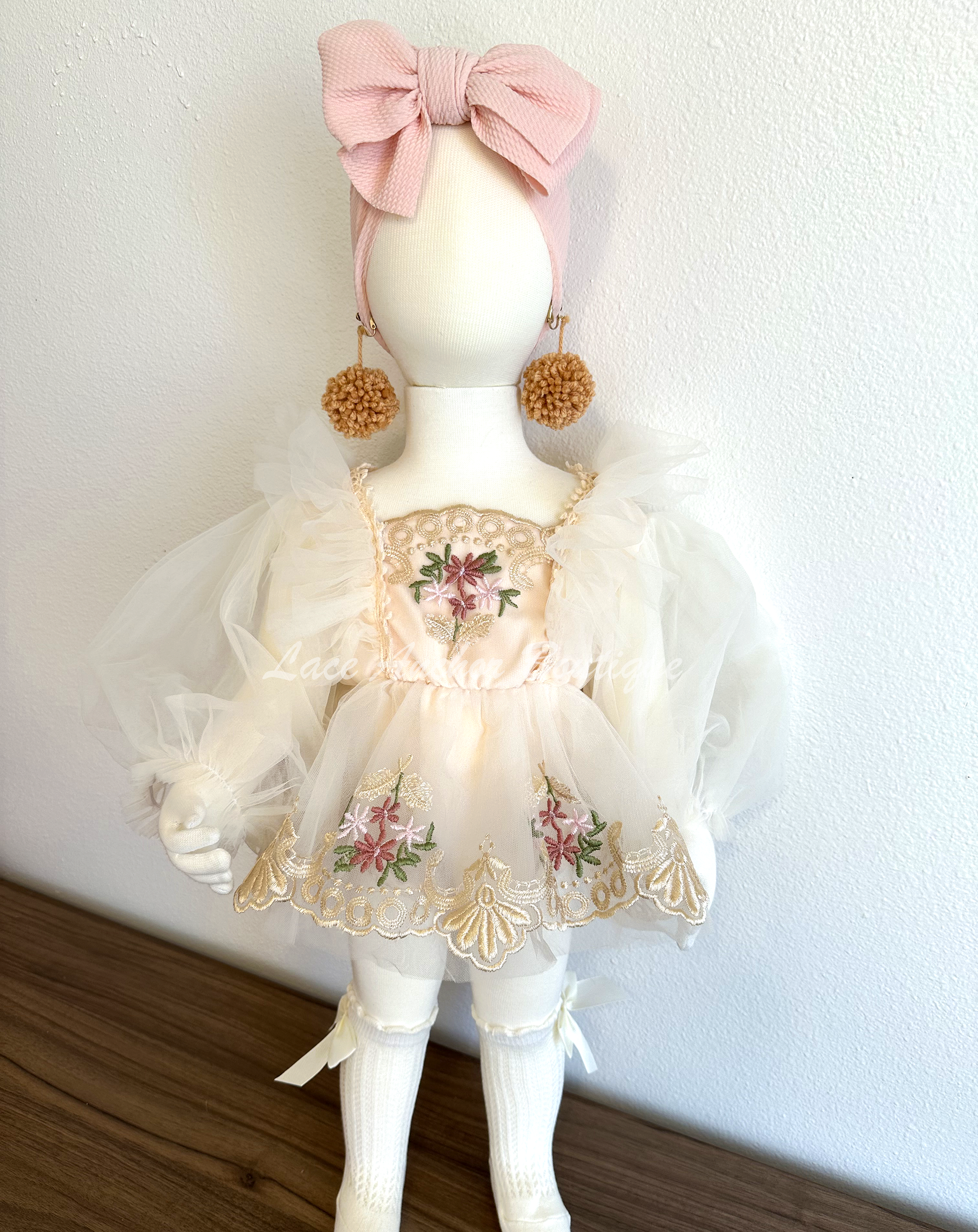 baby toddler girls flower girl romper with long puff sleeves, embroidered gold floral trim, skirt, and tied back. In white