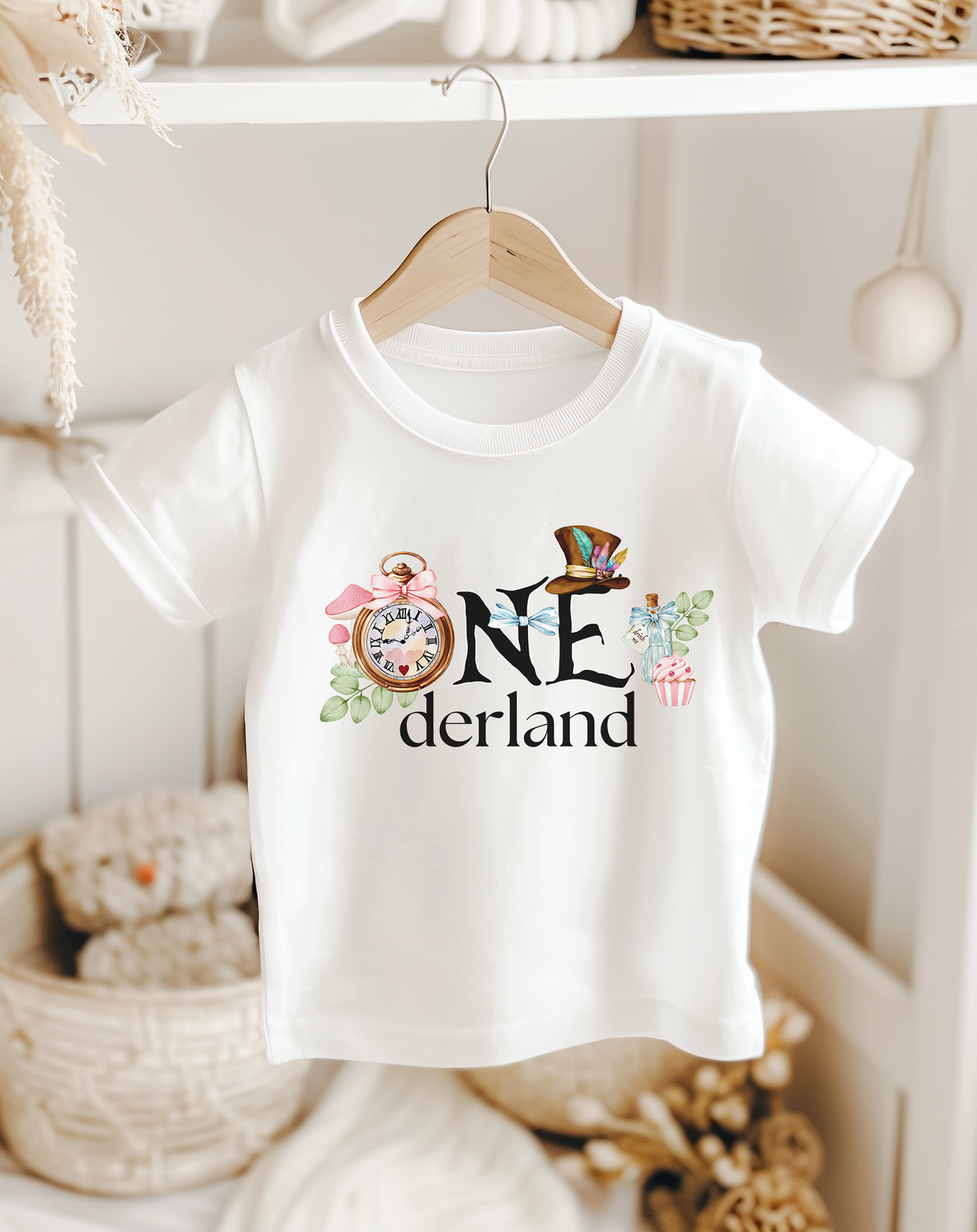 baby girls white first birthday shirt in an Alice in Wonderland theme. Featuring ONEderland across the chest with a clock for the O, florals, Mad Hatters Hat, and related details.