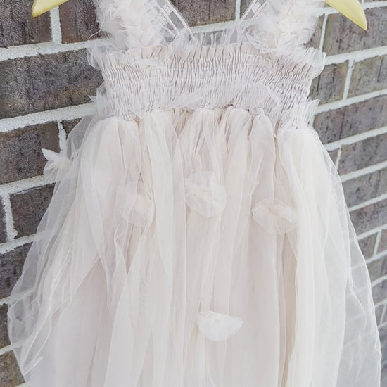 Champagne beige tulle fairy girls dress with smocked top and tulle flowers on skirt. Attached butterfly wings and ruffled straps.