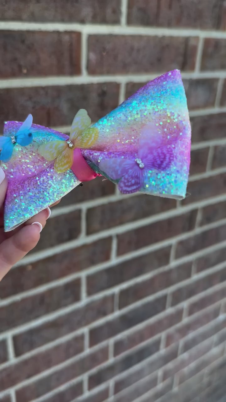 pastel rainbow colored girls hair bow clip with multi colored butterflies and glitter