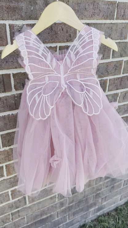 Mauve pink tulle fairy girls dress with smocked top and tulle flowers on skirt. Attached butterfly wings and ruffled straps.