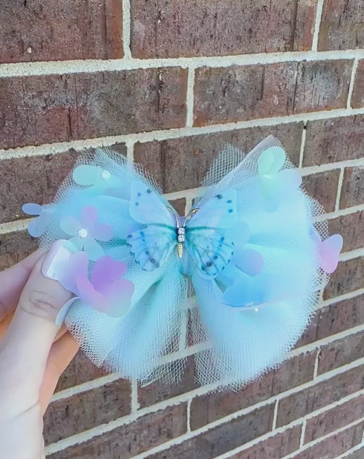 light blue tulle hair bow with flowers and pink and gold butterfly center for toddler girls and up..